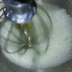 Whip the egg whites on low speed until foamy, then whip on medium speed while gradually adding sugar.